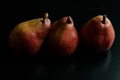 Three red pears on a black table Stock Photos