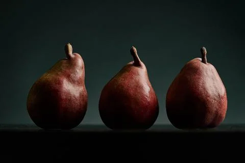 Three red pears on a black table Stock Photos