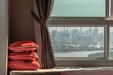Three red Pillows in the corner on Sofa bed with Curtain near Glass window. Stock Photos