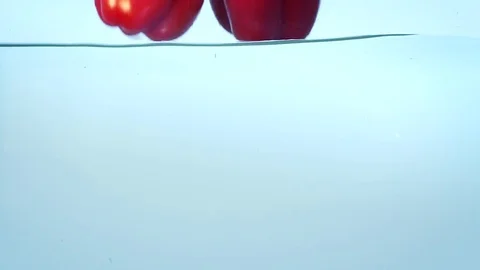 Three red ripe bell peppers in water slow motion. Stock Footage 76552487