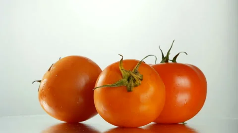 Three red tomatoes rotating in slow motion over white background Stock Footage 86393968
