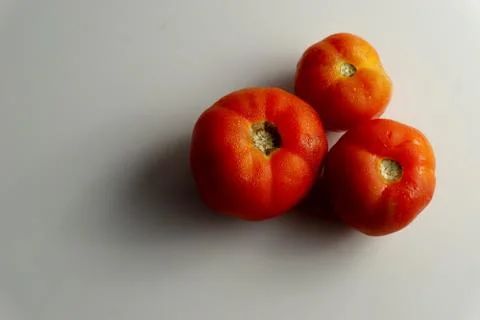 Three red tomatoes on the table Stock Photos