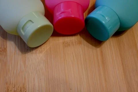 Three refillable shower bottles in different colors for travel, sustainable pers Foto stock