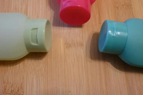 Three refillable shower bottles in different colors for travel, sustainable pers Stock Photos