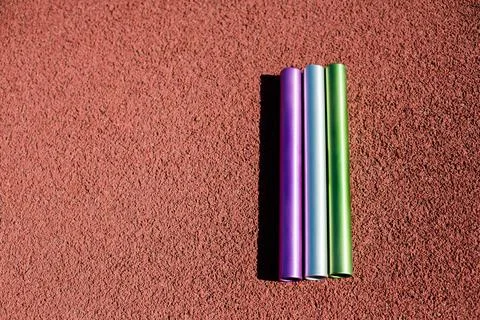 Three relay batons on the ground Stock Illustration