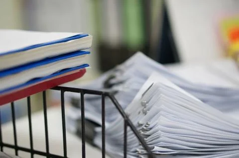 Three of report notebook on black shelf rack and pile of white data papers sh Foto stock