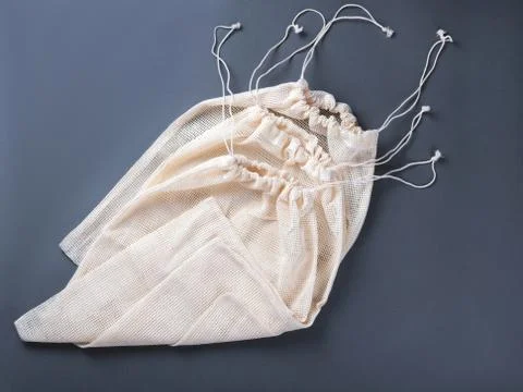 Three reusable string bags for different products on the grey background. Stock Photos