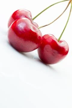 Three ripe cherries on a white background Stock Photos