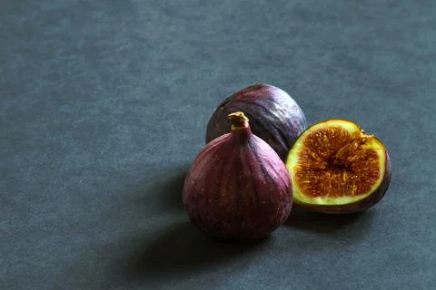 Three ripe figs on a gray background. Stock Photos
