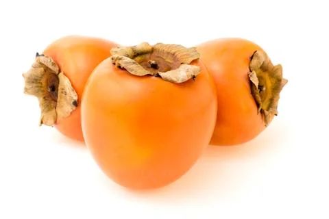Three ripe persimmons on a white Stock Photos