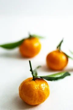 Three ripe tangerines with leaves close-up on a light background. Copy space Stock Photos