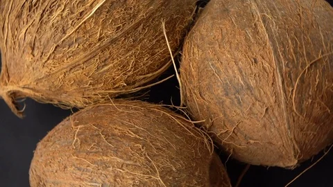 Three ripe tropical coconuts rotating on a black background. Tropical fruits and Stock Footage 71178854