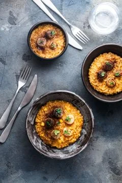 Three risotto bowl on stone background, top view Stock Photos