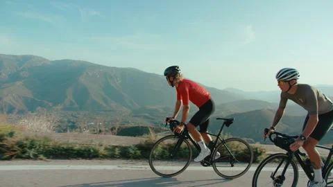 Three road cyclists descend mountain road Video stock 264123284
