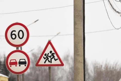 Three road signs stand together. a sign overtaking is forbidden, the speed Stock Photos