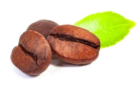 Three roasted coffee beans and green leaf Stock Photos