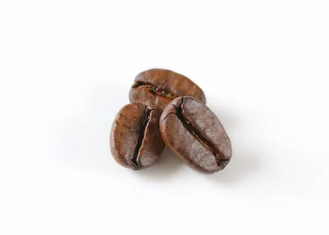 Three roasted coffee beans close up Stock Photos