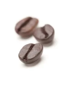 Three Roasted Coffee Beans Isolated on White with Narrow Depth of Field. Stock Photos