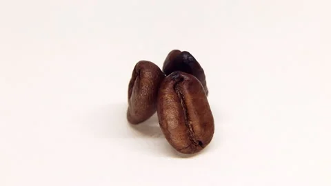 Three roasted coffee beans rotating macro Video stock 143425748