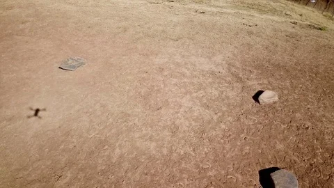 Three rock, dusty floor and hovering drone shadow Stock Footage 89834828