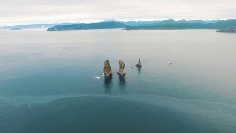 Three rocks in the ocean. Rock in the sea. Birds on the coast of the island in Stock Footage 73524442