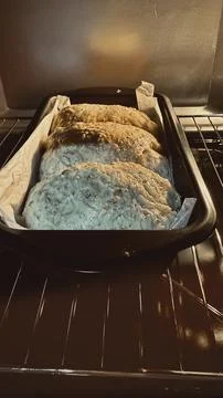 Three rolls of  Final proof dough lined with  parchment paper is in Oven Stock Photos