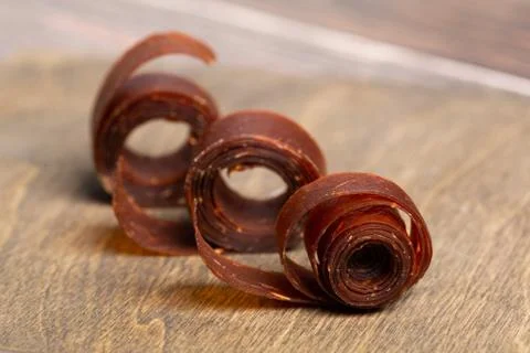 Three rolls of fruit paste on a wooden table. Stock Photos