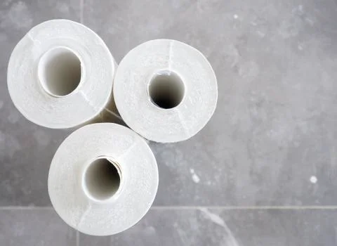 Three rolls of white Wallpaper on gray tile floor.House renovation,wallpaperi Stock Photos