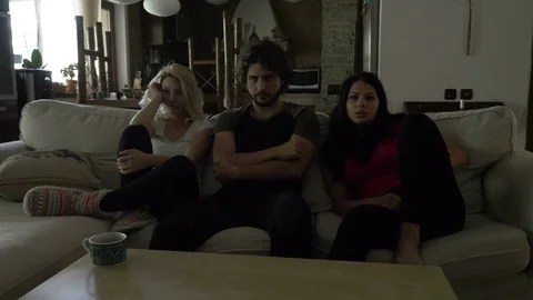 Three roommates spend the evening together watching a movie indoor Stock Footage 79317387