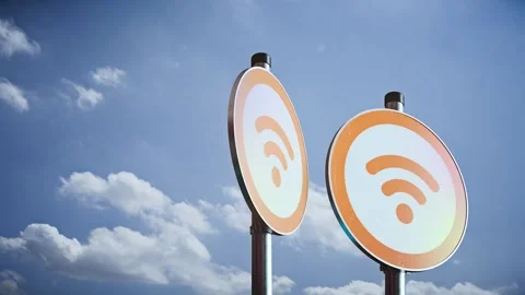Three rotating public WiFi hotspot signs on poles against blue sky, orange Stock Footage 336319246