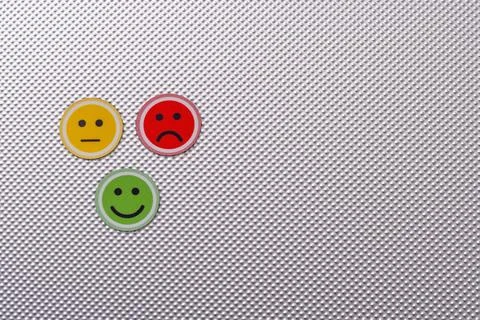 Three round emoji faces in red, yellow, and green representing sad, neutral, and Stock Photos