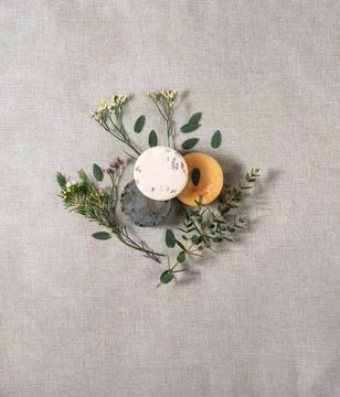 Three round handmade soaps with the twigs of flowers on the cotton background Stock Photos