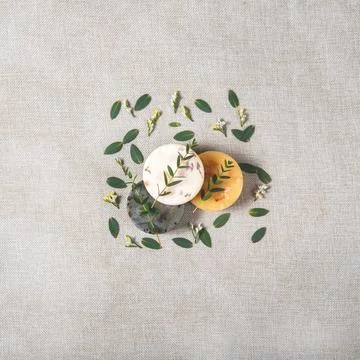 Three round natural handmade soaps with the eucalyptus on the cotton background. Stock Photos