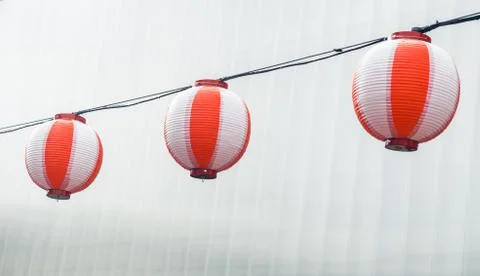 Three round paper red-white japanese lanterns Chochin hanging on garland sky Stock Photos