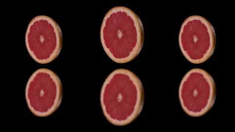 Three round slices of grapefruit isolated on a black background. Stock Photos