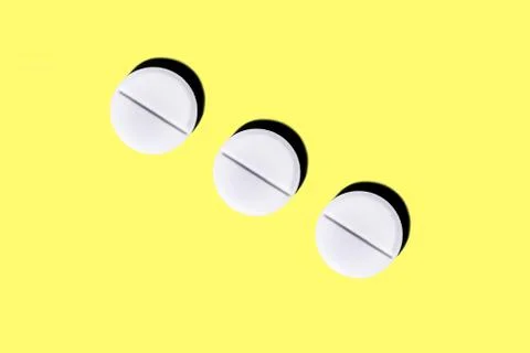 Three round tablets on a yellow background. Stock Photos