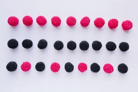 Three rows of jelly in the form of red raspberries and black blackberries o.. Stock Photos