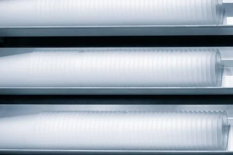 Three rows of white plastic cups are stacked on top of each other. The cups a Stock Photos