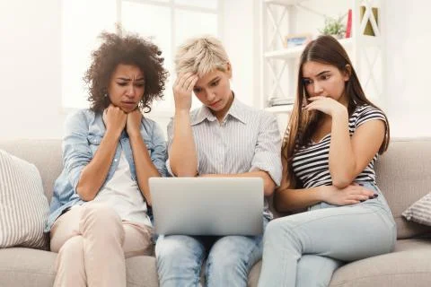 Three sad women using laptop at home Stock Photos