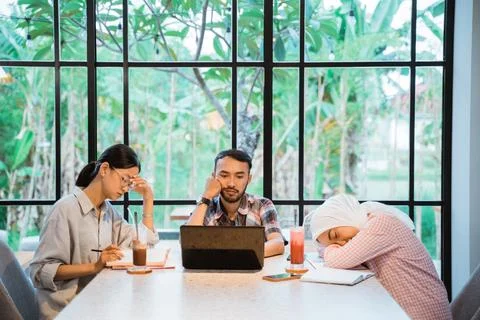 Three sad young people using a laptop while working together Stock Photos