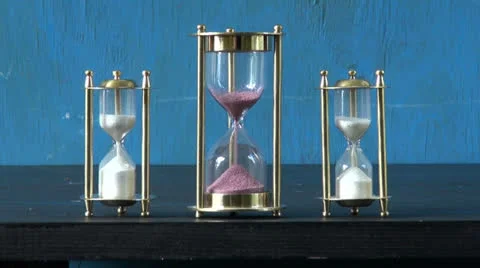 Three sand glass, hourglass on table and sand flow motion Stock Footage 25782835