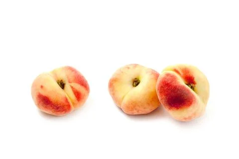 Three saturn peaches or flat peaches isolated on white background with clip.. Stock Photos
