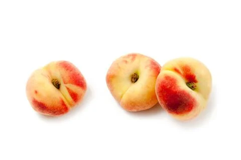 Three saturn peaches or flat peaches isolated on white background with clip.. Stock Photos