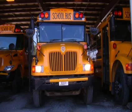 Three school buses parked in garage Stock Footage 21624006