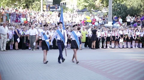 Three schoolchildren marching with flag. School.  1 September. Stock Footage 67587792