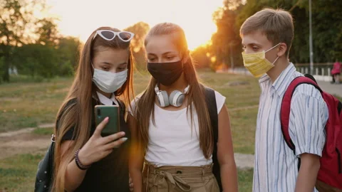 Three schoolchildren in protective masks take a selfie Stock Footage 137907859
