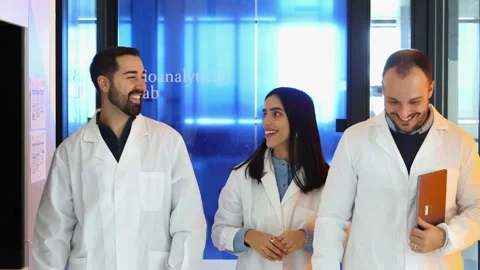Three Scientists smiling and walking in bioanalytical laboratory Stock-Footage 296884990