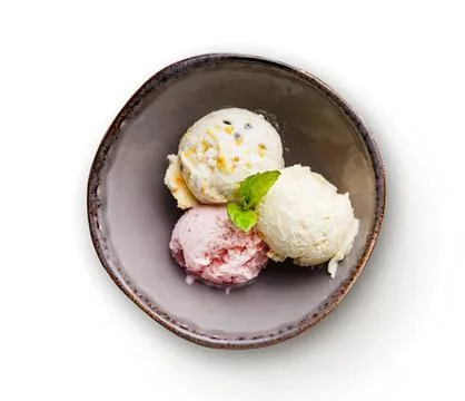 Three scoops of ice cream in a dark bowl with mint leaf Stock Photos