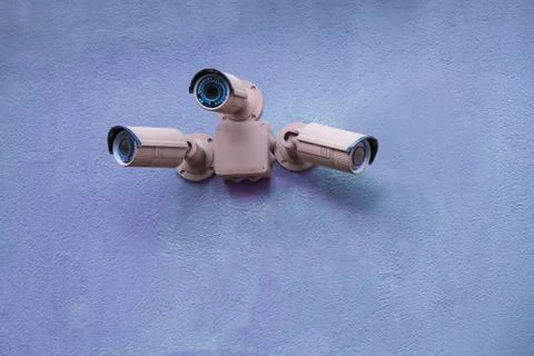 Three security cameras on blue wall Stock Photos