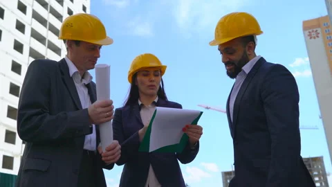 Three serious business man at a construction site on a building background. Men Stock Footage 89216163
